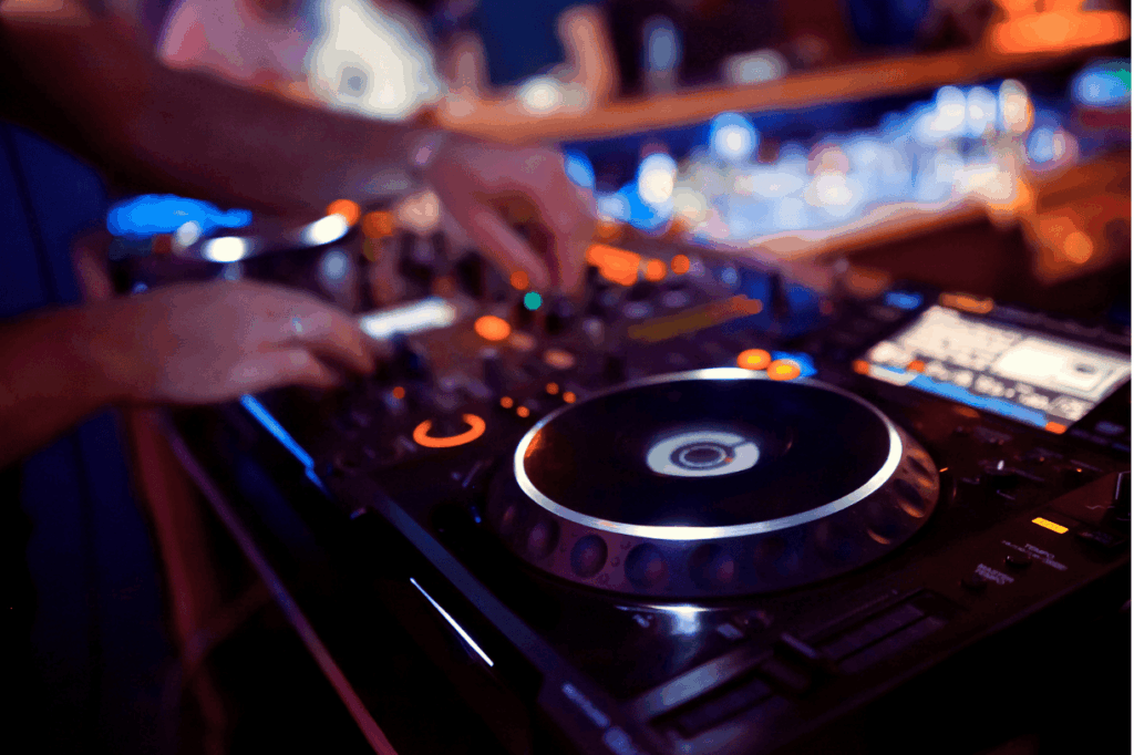 DJ legt Musik auf mit beleuchtetem Mischpult bei einer stimmungsvollen Hochzeitsfeier