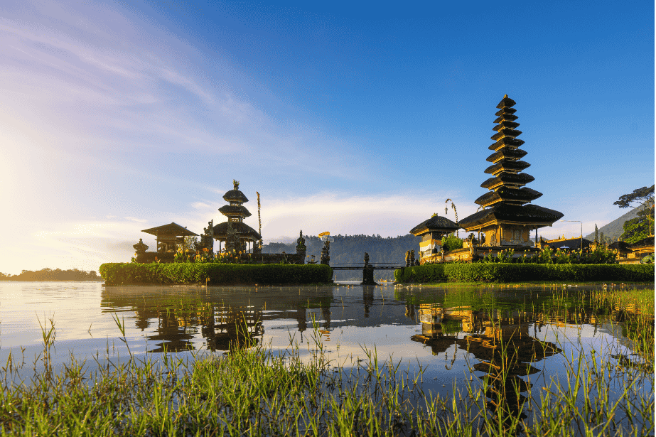 Der ikonische Wassertempel Pura Ulun Danu Beratan auf Bali, dessen Pagoden sich bei Sonnenaufgang im ruhigen Bratan-See spiegeln.